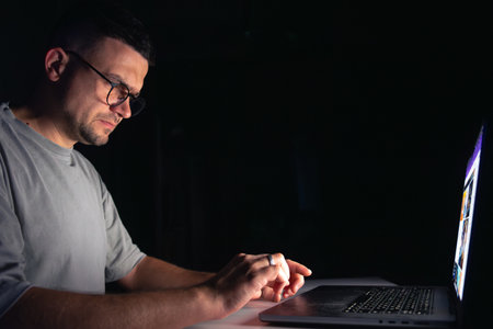 Young man works at the computer at night.の写真素材
