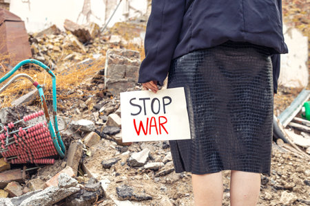Young woman with message stop war. House destroyed by the war.の写真素材