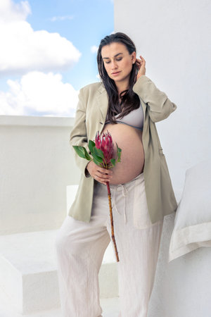 Pregnant woman with protea flowers. Concept of style and pregnancy.