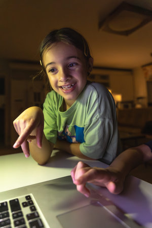 Beautiful girl studies at the computer at night. Technology and education.