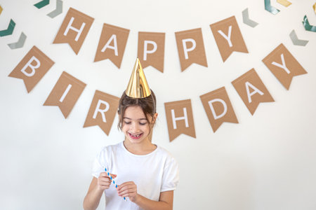 Happy girl celebrating her birthday. Birthday concept. A girl in a festive hat.の写真素材