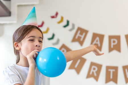 The girl inflates a balloon. Birthday concept. A girl with an inflatable ball.の写真素材