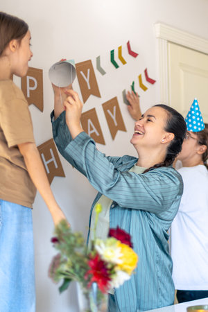 A mother helps her daughter prepare for her birthday. Birthday concept.の写真素材