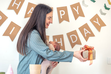A mother with a newborn baby in her arms celebrates her birthday.の写真素材