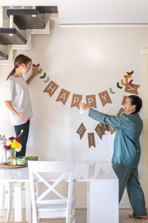 A mother helps her daughter prepare for her birthday. Birthday concept.の写真素材