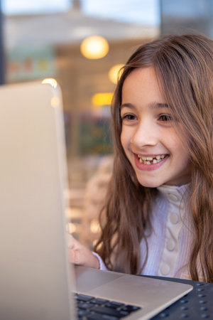 A happy girl is working on a laptop. Girl and laptop. Technology conceptの写真素材