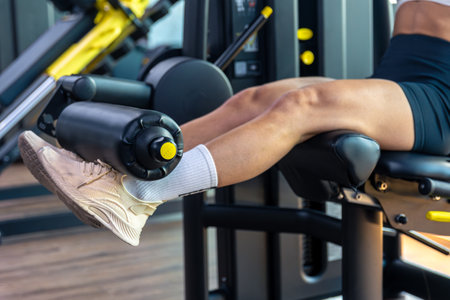 Sporty girl on the simulator swings her legs. Sport healthy lifestyle concept.の写真素材