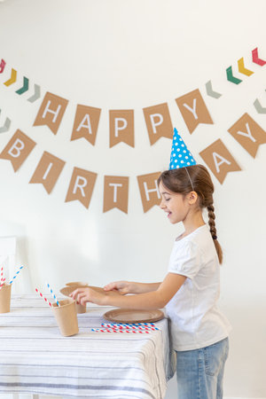 The girl decorates the festive table for her birthday. Birthday concept.の写真素材