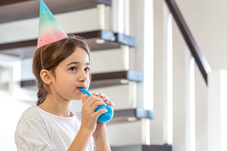 The girl inflates a balloon. Birthday concept. A girl with an inflatable ball.の写真素材