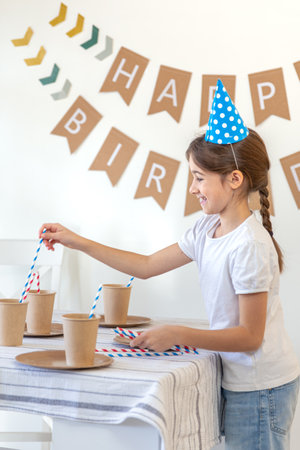 The girl decorates the festive table for her birthday. Birthday concept.の写真素材