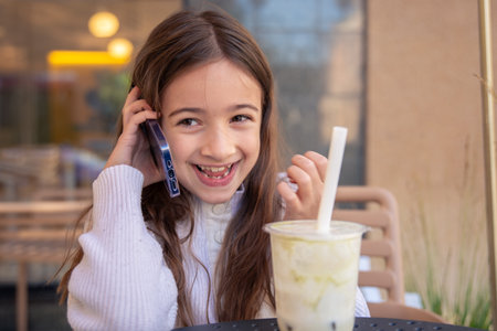 A girl with a phone. The girl is talking on the phone.の写真素材