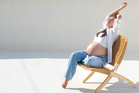 Joyful pregnant woman on the background of the sky. Concept of pregnancy.の写真素材