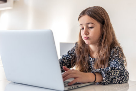 A sad girl is working on a laptop. Sad girl and laptop. Technology concept.の写真素材