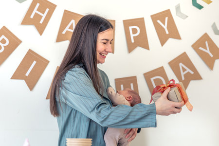 A mother with a newborn baby in her arms celebrates her birthday.の写真素材
