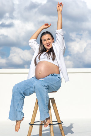 Joyful pregnant woman on the background of the sky. Concept of pregnancy.の写真素材