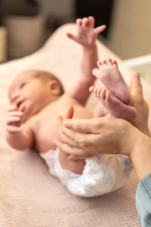 Parent holding in the hands feet of newborn baby. Mom holding baby feet.の写真素材
