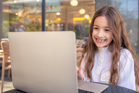 A happy girl is working on a laptop. Girl and laptop. Technology conceptの写真素材