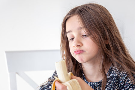 The girl is eating a banana. Concept of emotions.の写真素材