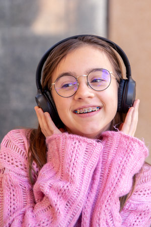 Happy teenage girl in headphones listening to music. Emotions concept.の写真素材