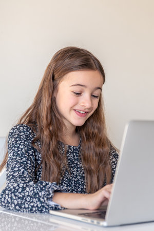 A happy girl is working on a laptop. Girl and laptop. Technology conceptの写真素材