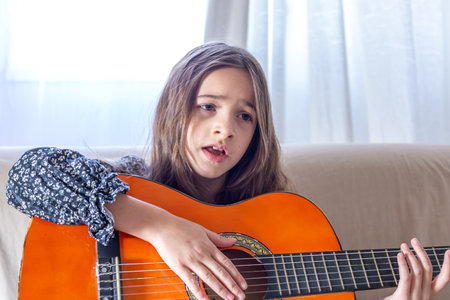 The girl plays the guitar at home. Girl and guitar.の写真素材