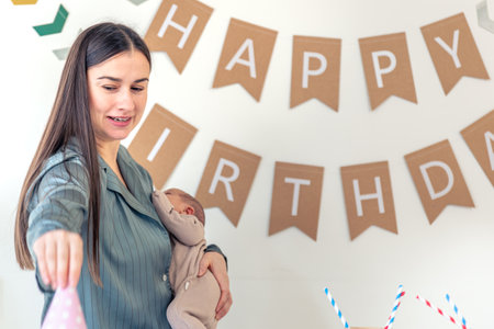 A mother with a newborn baby in her arms celebrates her birthday.の写真素材