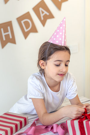 A cute girl opens her holiday presents. Birthday concept.の写真素材