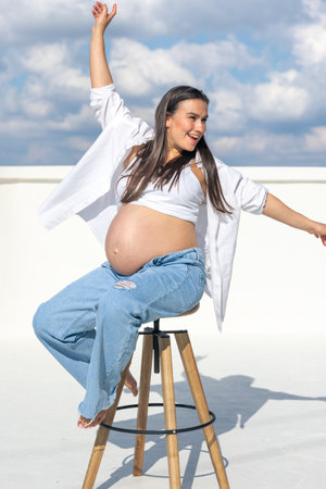 Stylish pregnant woman on a chair. Concept of style and pregnancy.の写真素材