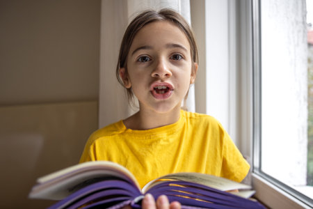 The girl reads carefully. Emotion and education concept.の写真素材