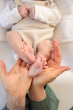 Parent holding in the hands feet of newborn baby. Mom holding baby feet.の写真素材