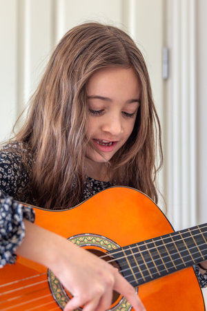 The girl plays the guitar at home. Girl and guitar.の写真素材