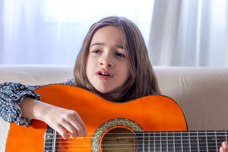 The girl plays the guitar at home. Girl and guitar.の写真素材