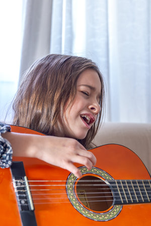 The girl plays the guitar at home. Girl and guitar.の写真素材