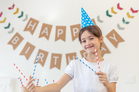 Happy girl celebrating her birthday. Birthday concept. A girl in a festive hat.の写真素材
