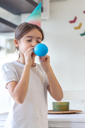 The girl inflates a balloon. Birthday concept. A girl with an inflatable ball.の写真素材