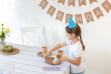 The girl decorates the festive table for her birthday. Birthday concept.の写真素材