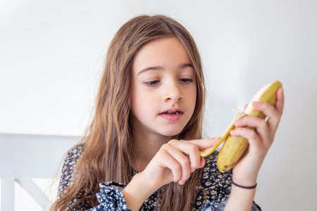 The girl is eating a banana. Concept of emotions.の写真素材