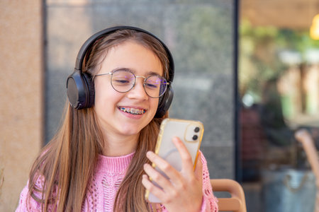 Happy teenage girl in headphones listening to music. Emotions concept.の写真素材