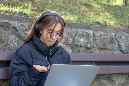 A girl in headphones works at a laptop. A girl with a laptop.の写真素材