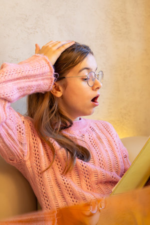 Surprised teenage girl reading a book. Emotion concept.の写真素材