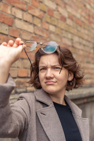 Portrait of a beautiful young woman holding glasses in her hand. Close up.の写真素材