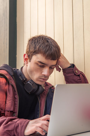 A student studies using a laptop. Male student studying online.の写真素材
