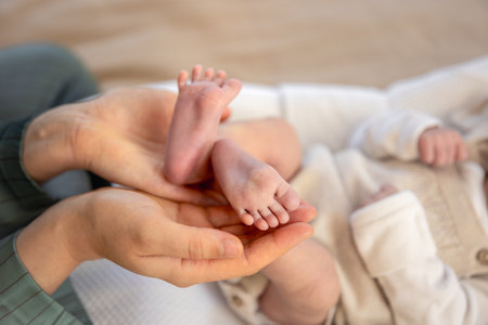 Parent holding in the hands feet of newborn baby. Mom holding baby feet.の写真素材