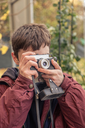 A young man takes pictures on a vintage camera. Film camera photography.の写真素材