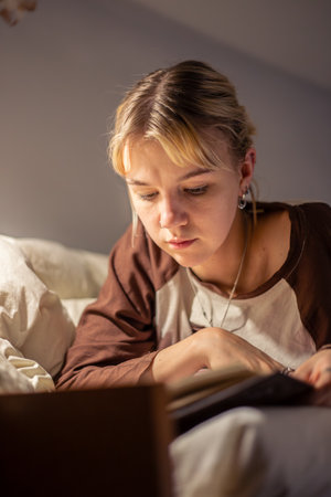 Young woman reading a book during a blackout. Reading a book in the dark.の写真素材