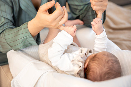 A mother plays with a newborn baby. Newborn baby.の写真素材
