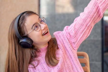 Happy teenage girl in headphones listening to music. Emotions concept.