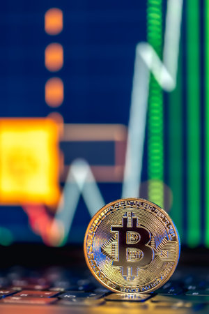 Golden Bitcoin coin on keyboard. Stock market trading chart online candlestick.の写真素材