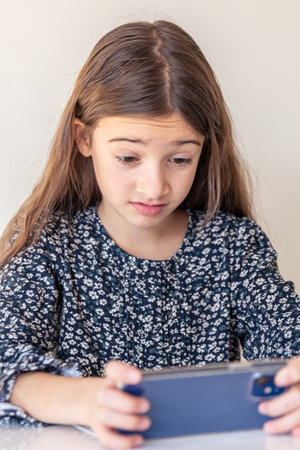 The girl plays mobile games on the phone. A girl with a phone.の写真素材