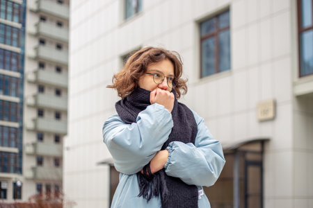A young beautiful girl suffers from cold weather.の写真素材